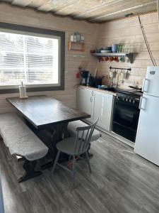 eine Küche mit Tisch, Stühlen und Kühlschrank in der Unterkunft Kärrända in Nedervetil