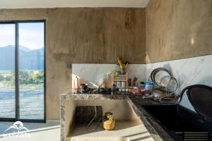 una cucina con un lavello e una grande finestra di Prada & Abby Hill by Bukit Vista a Kubupenlokan