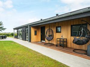 ein Haus mit zwei Schaukeln an der Seite in der Unterkunft 10 person holiday home in Vinderup-By Traum in Vinderup