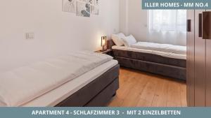 Un dormitorio con dos camas y una ventana. en Iller Homes Memmingen - 3 x Moderne Fewos mit Terrasse für bis zu 7 Pers mit Parkplätzen, en Memmingen