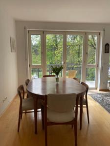 a dining room with a wooden table and chairs at Helle Wohnung am Waldpark in Dresden