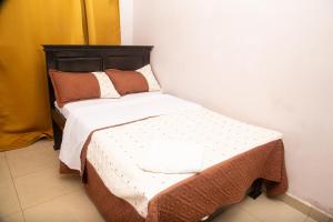 a small bed in a room with at The Ankh Guest House in Kampala +8 photos