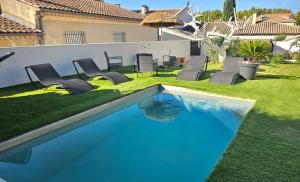 a swimming pool in a yard with chairs and a house at Villa Provence Baraka centre-ville in Salon-de-Provence