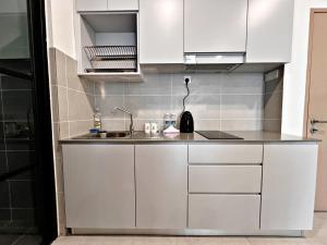 a kitchen with white cabinets and a sink at Modern 2-Bedroom Escape in Kuching