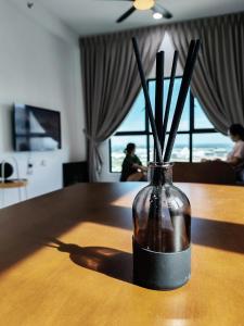 un vase avec des bâtons dedans posé sur une table dans l'établissement Brand NEW Modern Cozy Retreats 3BR2B2P for 6, à Batu Kawan