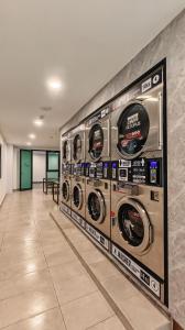 une rangée de lave-linge dans une pièce dans l'établissement Brand NEW Modern Cozy Retreats 3BR2B2P for 6, à Batu Kawan