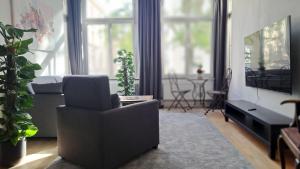 un salon avec un canapé et une télévision dans l'établissement Beletage Cologne, à Cologne