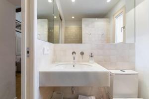 シッチェスにあるCasa Alba Garden & Calmの洗面台と鏡のある白いバスルーム