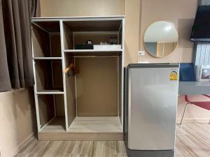 a kitchen with a refrigerator and a shelf at S1 City Hotel Buriram in Buriram