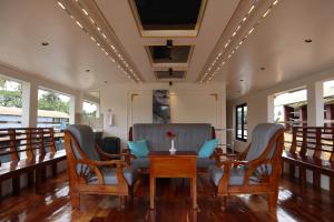 a dining room with chairs and a table with a vase at Kera Houseboats Alleppey in Alleppey