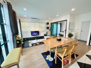 a living room with a wooden table and chairs at See Sky Poolvilla Khao Yai in Ban Nong Ka Cha