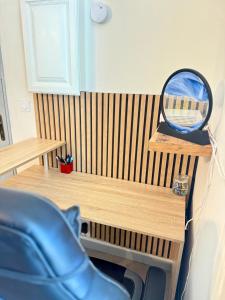 un espejo sentado en la parte superior de un banco de madera en Le Continental - Calme et Centre-Ville, en Aix-les-Bains