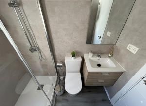 Un baño con inodoro, lavabo y ducha. en Apartamentos El Savio, en Ronda 7 fotos más