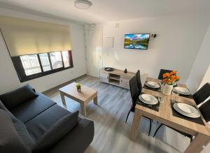 sala de estar con sofá y mesa de comedor en Apartamentos El Savio, en Ronda
