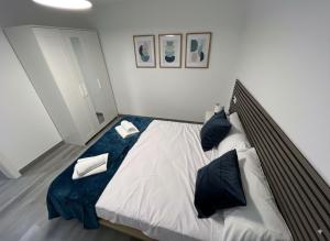 1 dormitorio con 1 cama grande con almohadas negras en Apartamentos El Savio, en Ronda