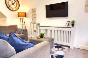 a living room with two couches and a tv on the wall at Northfield Home in Longbridge