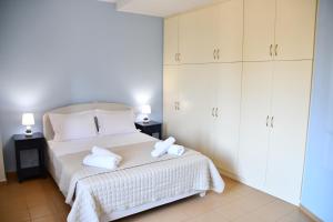 a bedroom with a bed with two towels on it at Blue and Green Guesthouse in Mystras