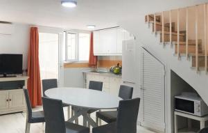 トレモリノスにあるGorgeous Apartment In Torremolinosのテーブルと椅子のあるキッチンとダイニングルーム