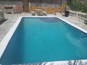 a large blue swimming pool with a patio at Bayview Luxury Retreat  +20 photos
