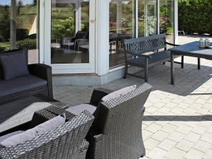 a patio with two chairs and a bench and a table at Luxury Retreat with Spa - By Traum Ferienwohnungen in Marielyst