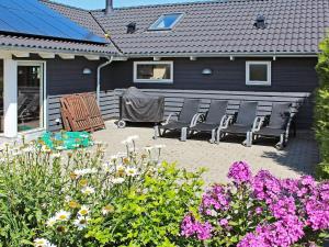 a patio with chairs and flowers in front of a house at Luxury Retreat with Spa - By Traum Ferienwohnungen in Marielyst +31 photos