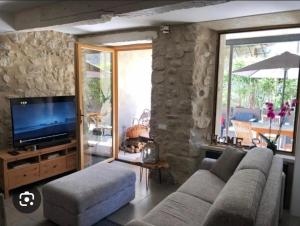 a living room with a couch and a flat screen tv at Agréable T2 calme centre-ville d'Annot in Annot