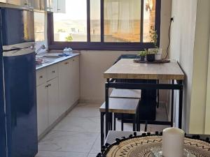 a small kitchen with a table and a refrigerator at הדס במדבר & Hadas in the Desert in Yeroẖam