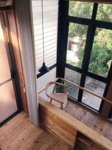 a chair sitting on a porch with a window at Vessel Hostel in San Juan