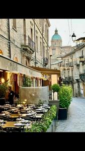 a restaurant with tables and chairs on a city street at Donna Elena by Armerina Sicily Apartments in Piazza Armerina