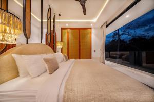 Un dormitorio con una cama grande con una ventana grande. en Ocean Verve Villa 3, en Uluwatu