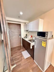 a small kitchen with a refrigerator and a sink at Makati Luxury Hotel Room Balcony Air Residence in Sampong +1 photo