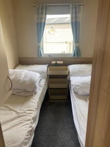 FlookburghにあるHaven Lakeland Caravan Hire in the Lake Districtの窓のある部屋にツインベッドが2台 +4枚の写真