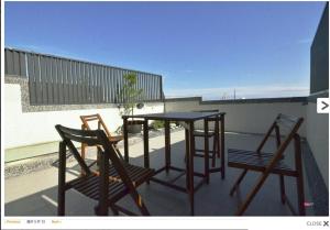 東港的住宿－蔚藍白鷺民宿，阳台配有2把椅子和1张桌子