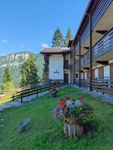 a building with flowers on the grass in front of it at Il Rifugio dell'Artista in Folgarida