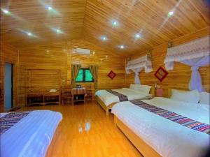 a bedroom with two beds and a desk in a room at A Páo Homestay in Pan Pho Piao Bong