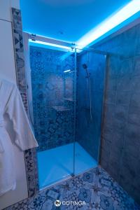 a shower with a blue light in a bathroom at Cotinga in Villars-les-Dombes