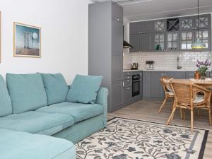a living room with a blue couch and a kitchen at 4 person holiday home in Fanø-By Traum in Fanø