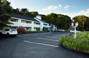 a parking lot with cars parked in front of a building at The Lodge at Turbat's Creek in Kennebunkport