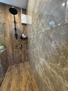 a bathroom with a shower with a stone wall at Rinda House Patong in Patong Beach