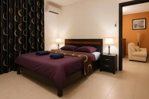 a bedroom with two beds and a chair and a mirror at Riviera Hermitage Luxury Apartment in Anjuna