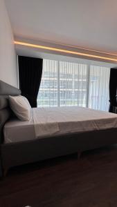een groot bed in een kamer met een raam bij Long Beach, İskele, Grand Sapphire Resort - Pool View Luxury Studio in Paralimni