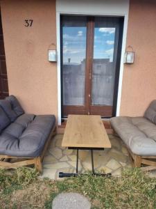 eine Terrasse mit zwei Sofas und einem Tisch und einem Fenster in der Unterkunft Maison sur vue montagne in Canet-en-Roussillon