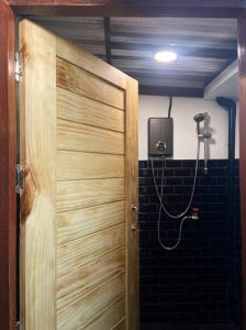 a bathroom with a wooden door and a shower at Charoen Hostel in Chanthaburi +9 photos