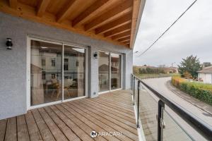 a wooden deck with glass doors on a house at Aracari in Villars-les-Dombes