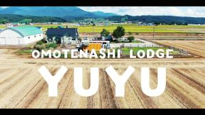 an aerial view of a farm with the words urbanwealth lodge ywx at ラベンダー畑まで5分ー最大10人ーお餅つきー流しそうめんー花火ー五右衛門風呂ー心と身体が元気になる古民家民泊ーオモテナシロッジ悠遊 in Nakafurano +92 photos