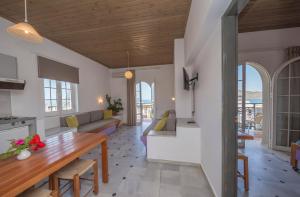 eine Küche und ein Wohnzimmer mit Holzdecke in der Unterkunft Manias Hotel Apartments in Agia Marina