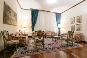 a living room with couches and chairs and a rug at Albergo Delle Notarie in Reggio Emilia