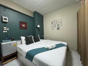 a bedroom with a large bed with a blue wall at Paksina Hotel in Narathiwat