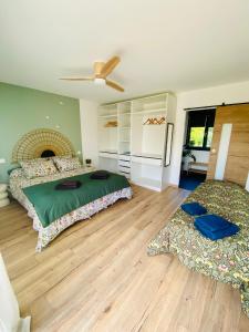 a bedroom with two beds and a ceiling fan at La Logette in Les Petites-Loges