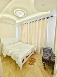 a bedroom with a bed and a suitcase on the floor at Serenity Gardens,pool retreat, Kigamboni in Dar es Salaam